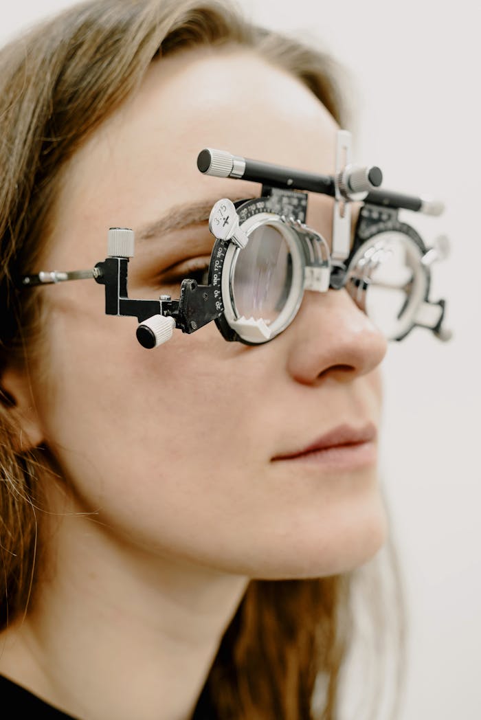 Close-up of a woman wearing trial glasses during an eye examination at a clinic.